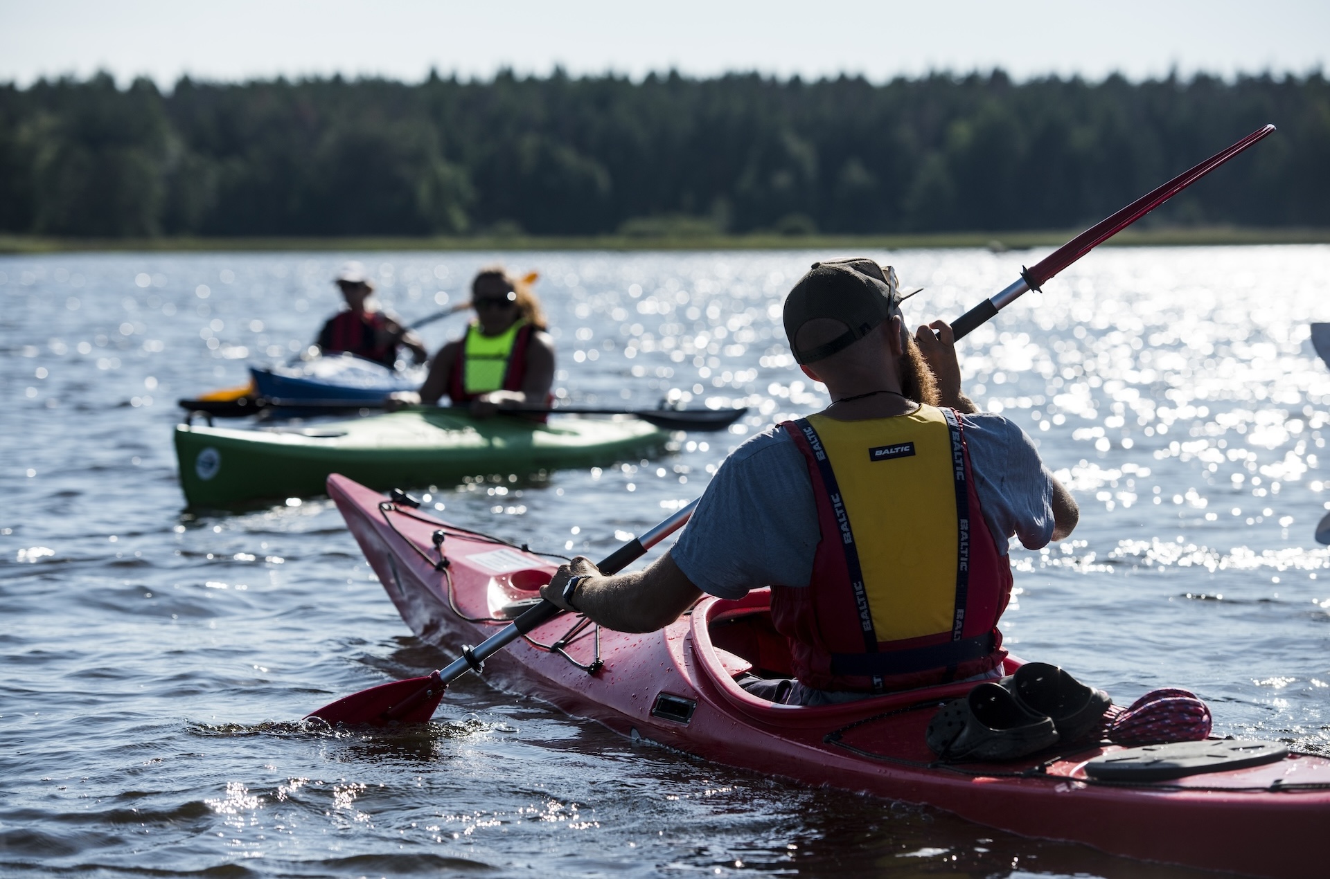 Tre personer paddlar i var sin kajak