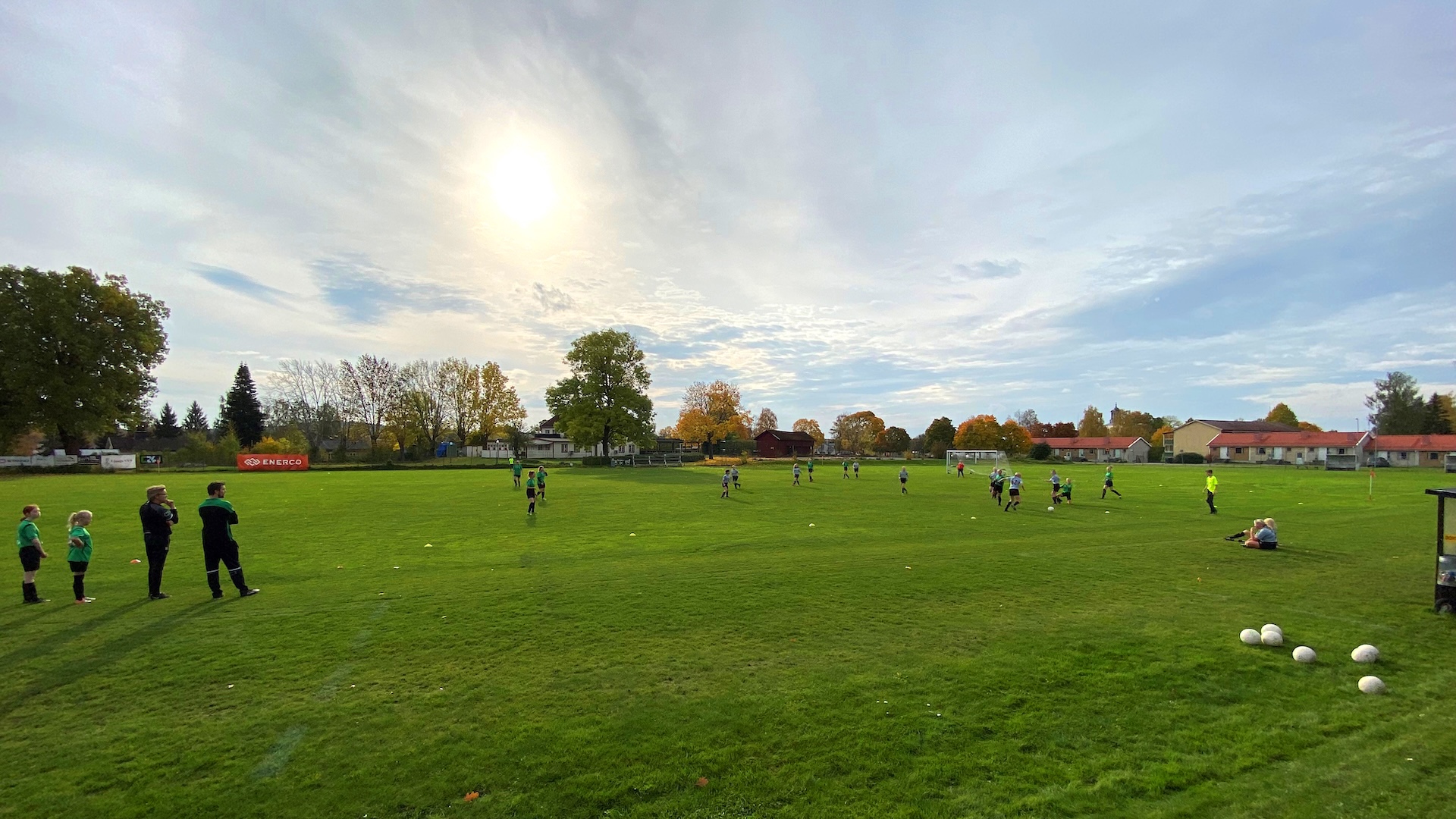 Barn och vuxna leker på grön äng