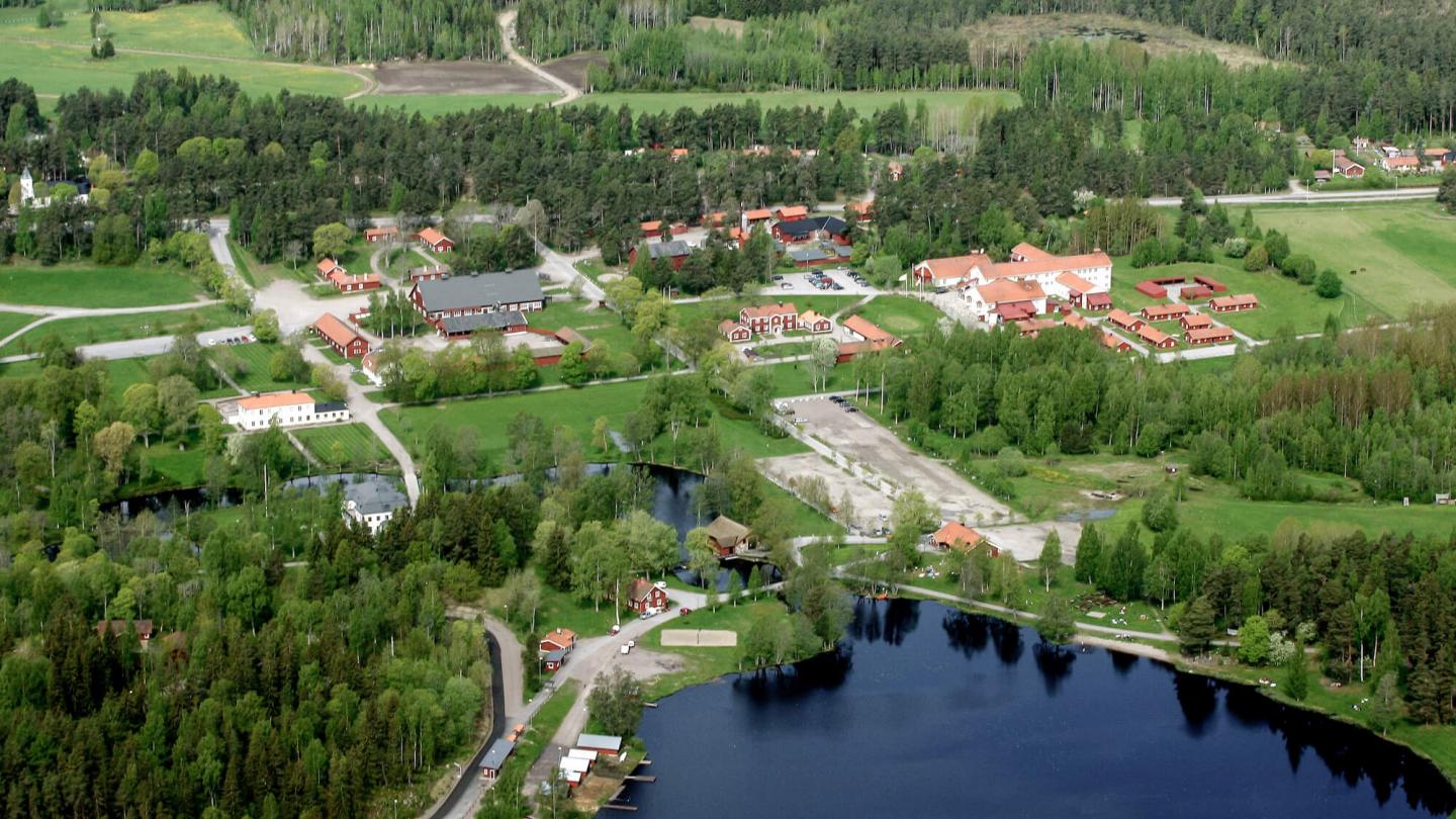 Flygbild över Högbo Brukshotell mellan skog och sjö