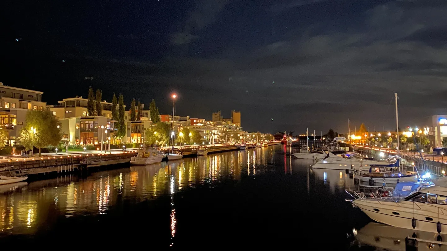 Gavleån om natten med upplysta hus runt om båtar