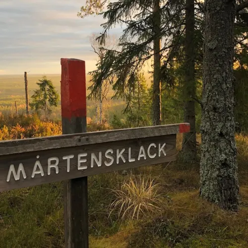Utsikt över dalen framför en skylt Mårtens klack