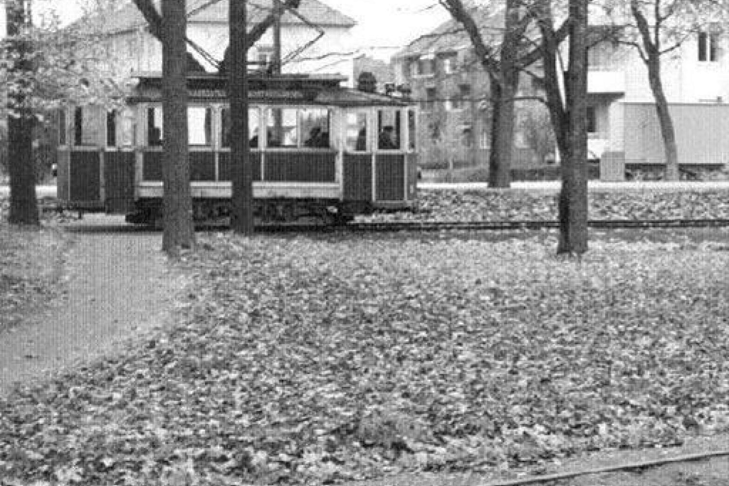 Den röda spårvagnen vid vändslingan i Stadsträdgården. I bakgrunden syns Västra vägen och dess bebyggelse.
