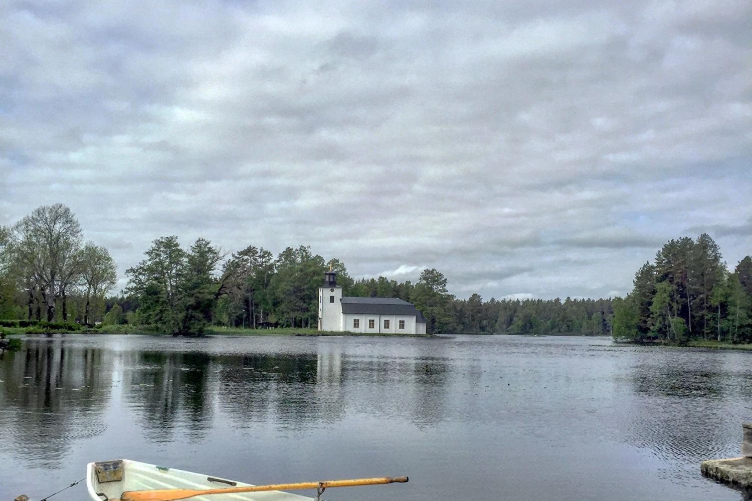 Oslättfors kyrka med båt i förgrunden. Foto Elena Vilhelmsson.