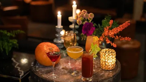 Ett bord av trätunna med en stämningsfull uppmaning av drinkglas, levande ljus och blomarrangemang