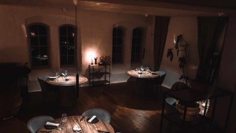 Restaurang med uppdukade bord i ett rum med dov belysning
